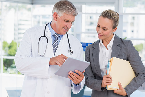 Doctor and businesswoman discussing in medical office.